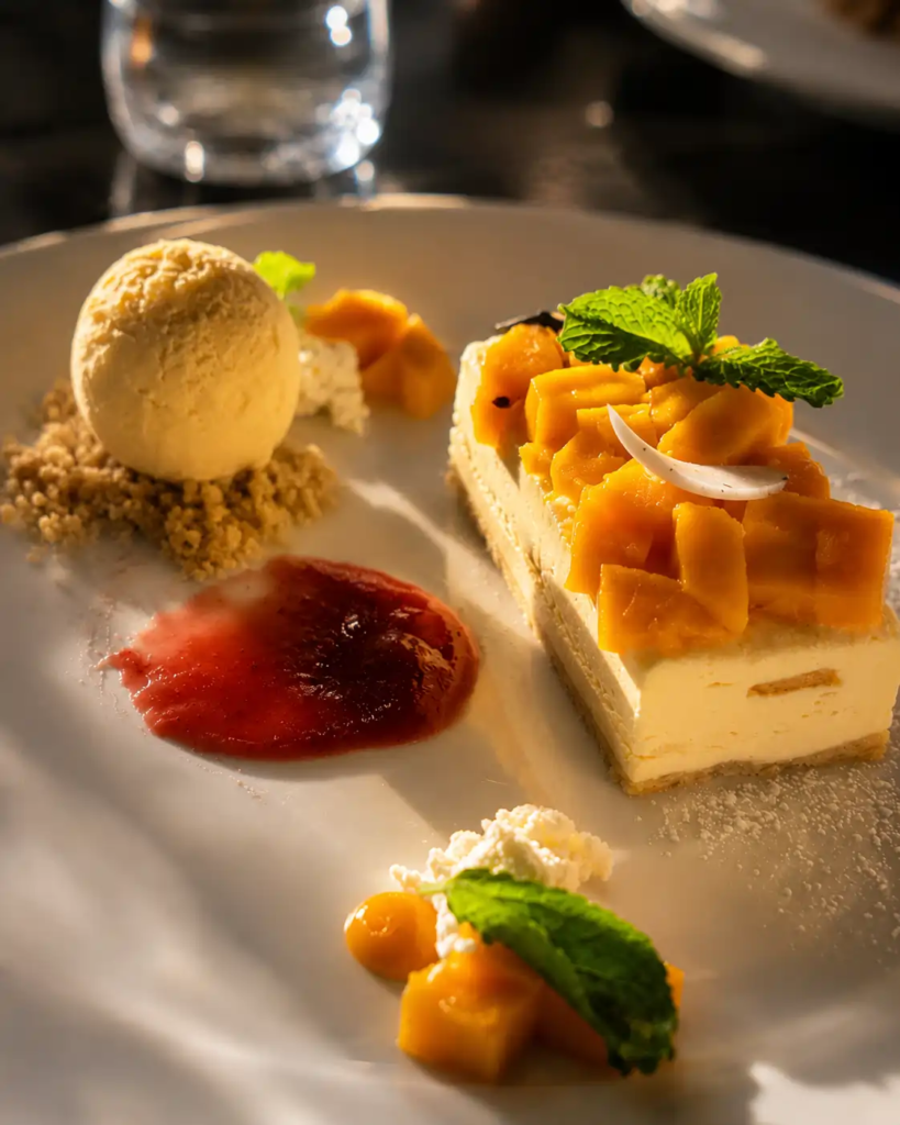 Alphonso Mango Ricotta dessert at Toscano Amanora featured in our Toscano Pune review, served with vanilla ice cream, fresh mango, and berry coulis.