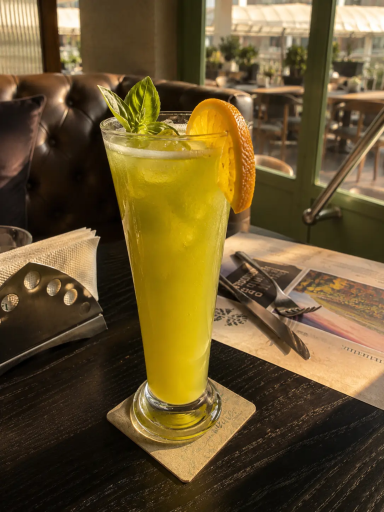 Basil Orange Mocktail at Toscano Amanora featured in our Toscano Pune review, served with fresh basil, orange slice, and ice.