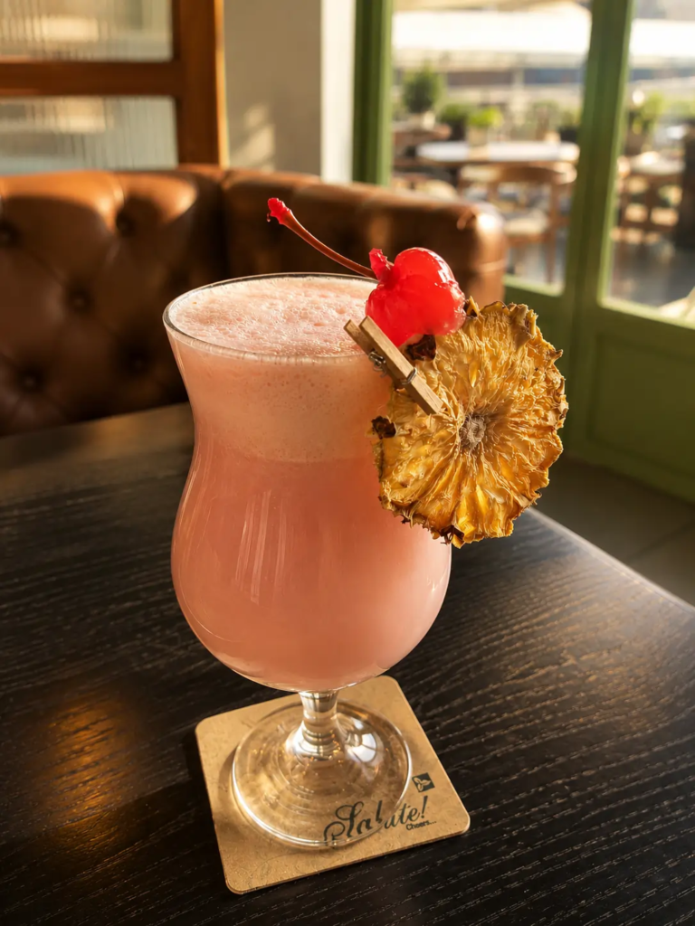 Strawberry Colada at Toscano Amanora featured in our Toscano Pune review, served with a cherry and dried pineapple garnish.